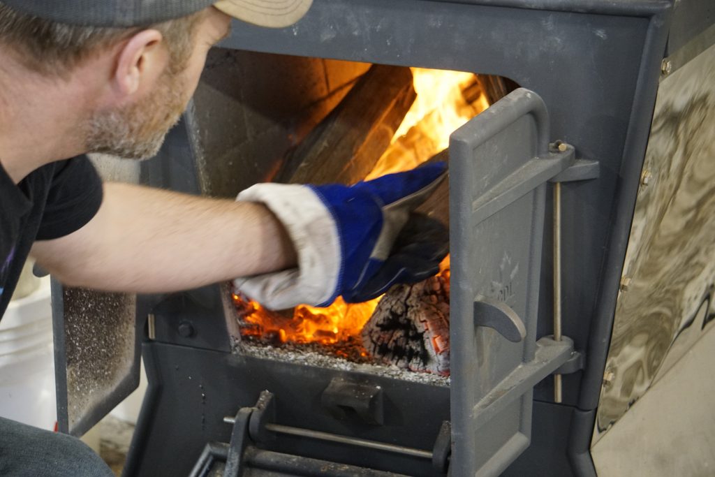 fire wood heating the evaporator in the pineland farms sugar house