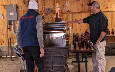 Sugar Maker showing cross country skier how to make syrup