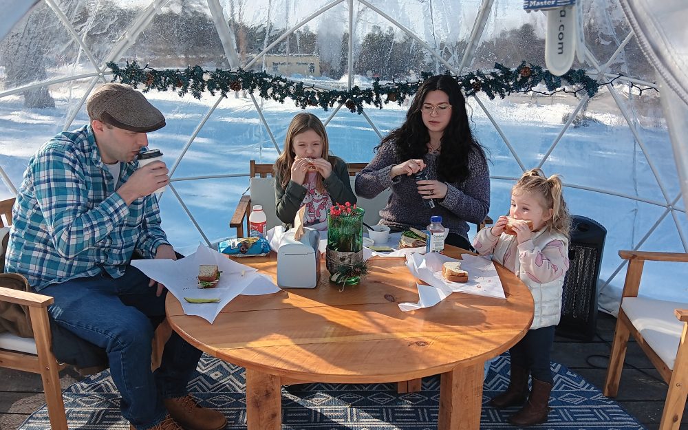 family enjoying food in snow globe at pineland farms