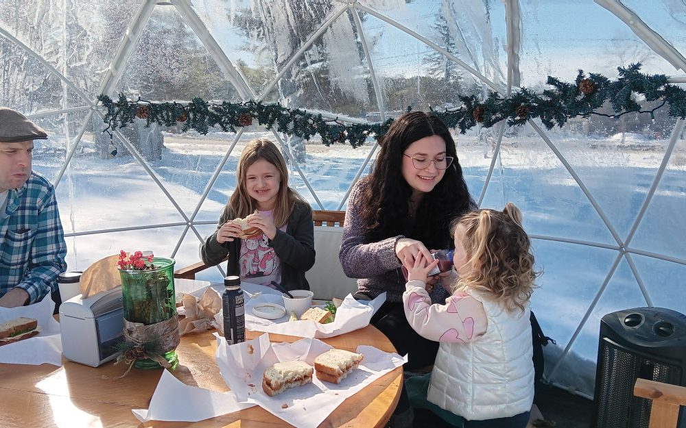 family enjoying food in snow globe at pineland farms